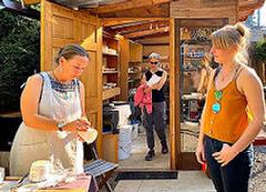 Monika Vitek, left, conversed with guests outside her Foster-Powell neighborhood art studio. She uses magnetic sand from the Oregon Coast to create porcelain pottery, jewelry, and paintings.
