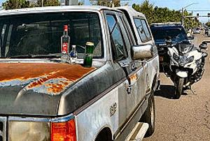 Along S.E. 82nd Avenue of Roses, just after the return of Portland Police Bureau�s Traffic Division, a drunk driver who also had arrest warrants was stopped and arrested. The open bottles and cans of the mini-bar he had in his vehicle are set out on the hood.
