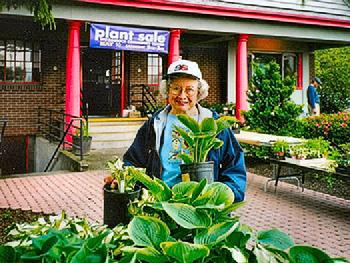 Jan Elliott, nicknamed the �Hosta Queen�, is shown here with her popular hosta plants for sale at the Woodstock Neighborhood Association plant sale in May of 2003.  