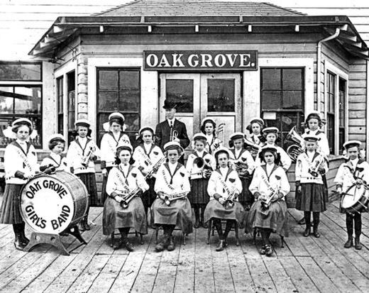 This 1912 photo shows the Oak Grove Girls Band in front of the streetcar waiting room on Railroad Avenue in Oak Grove. They were possibly waiting for the streetcar to take them to their next engagement. Formed in the summer of 1910, the young ladies performed for the next four years at some of Portlands top events -- including appearances at Oaks Park and Portlands Rose Festival.