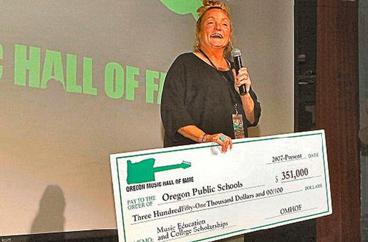 Highlighting the philanthropic purpose of the annual Oregon Music Hall of Fame Induction and Concert, the nonprofits Co-Founder Janeen Rundle used a big check to show how much theyve has raised so far, in 17 years, for Oregon music students education and scholarships.