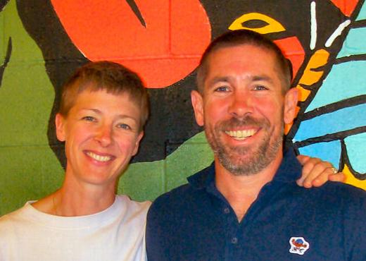 At right is Pete Hoppins, the owner of Away Days Brewery & Taproom  with his wife and manager, Niki, at left in front of the historic Brooklyn mural in the rear open space.