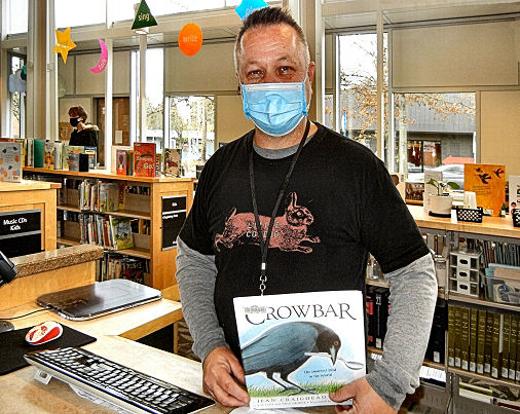 Marty Leisure, Woodstock Branch Library clerk, wants everyone to be able to enjoy books, such as this one he picked off the shelf.  A new �fine free� policy makes the library accessible to all, and he says, �It�s a great friendly approach.�